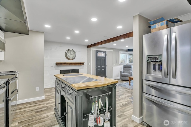 kitchen with stainless steel refrigerator with ice dispenser, baseboards, wooden counters, and light wood-style floors