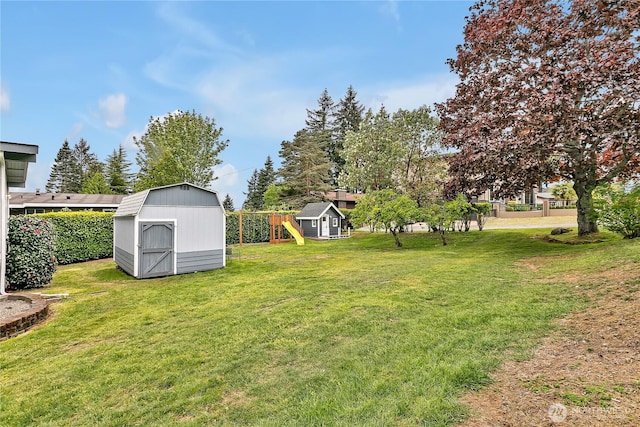 view of yard with a storage shed, an outdoor structure, and a playground