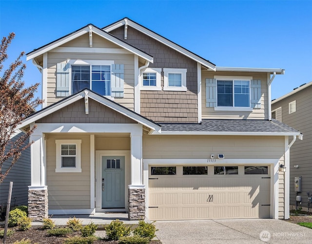 craftsman-style home with an attached garage, roof with shingles, and concrete driveway