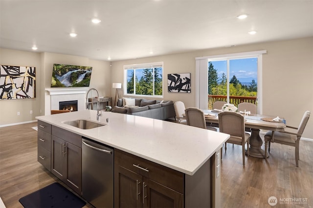 kitchen with a sink, baseboards, recessed lighting, wood finished floors, and dishwasher
