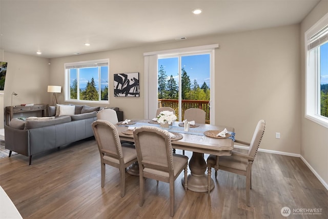 dining area featuring a healthy amount of sunlight, wood finished floors, and recessed lighting