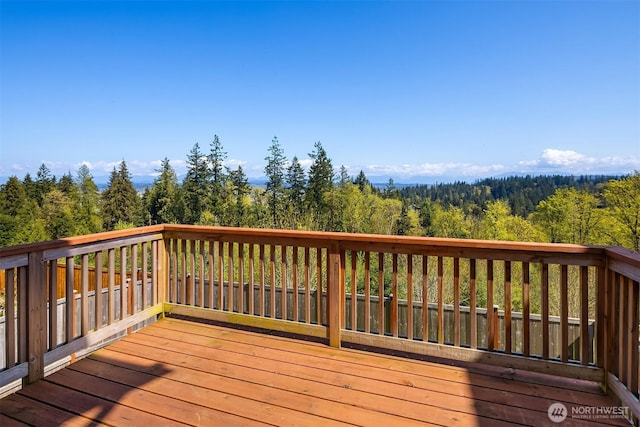 wooden terrace featuring a wooded view