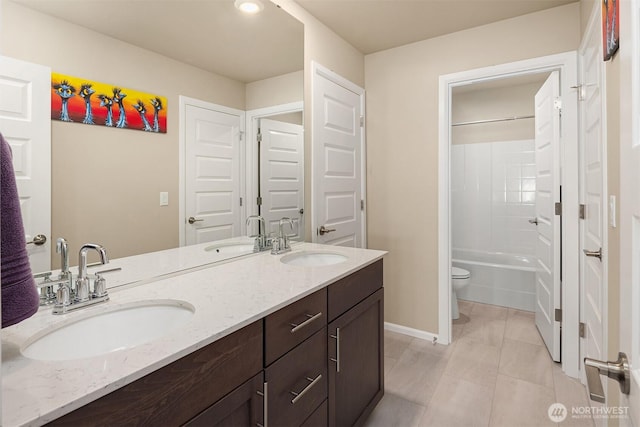full bathroom featuring toilet, a sink, and double vanity