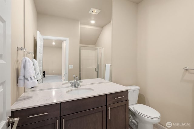 bathroom with baseboards, vanity, a shower stall, and toilet