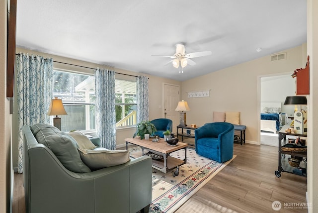 11325 126th St E Unit 229, Puyallup, WA 98374 - living room with light wood finished floors, vaulted ceiling, baseboards, visible vents, and ceiling fan