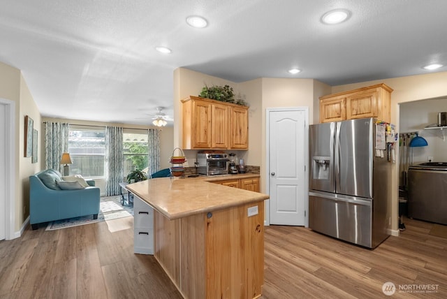 11325 126th St E Unit 229, Puyallup, WA 98374 - kitchen featuring a peninsula, light wood-style flooring, ceiling fan, stainless steel fridge with ice dispenser, and range