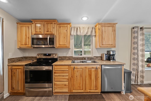 11325 126th St E Unit 229, Puyallup, WA 98374 - kitchen featuring light brown cabinetry, stainless steel appliances, light countertops, wood finished floors, and a sink