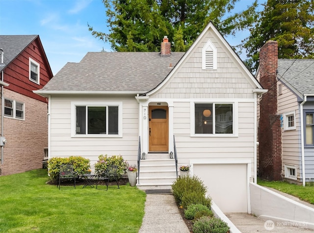 bungalow-style home with roof with shingles, a front lawn, concrete driveway, an attached garage, and entry steps