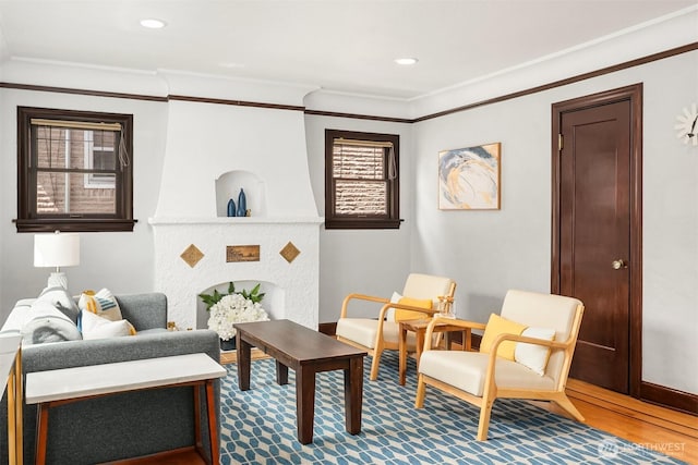 living area with a healthy amount of sunlight, ornamental molding, recessed lighting, and wood finished floors