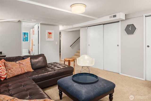 carpeted living area featuring visible vents and stairs