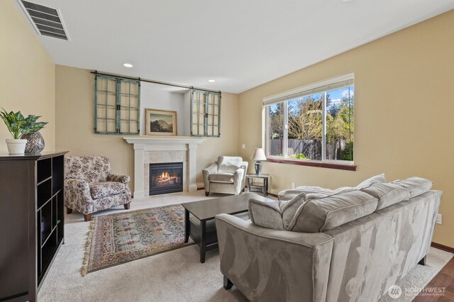 living room featuring a tiled fireplace, baseboards, recessed lighting, and visible vents