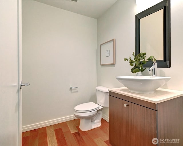 500 106th Ave NE Unit 3109, Bellevue, WA 98004 - bathroom with baseboards, wood finished floors, vanity, and toilet