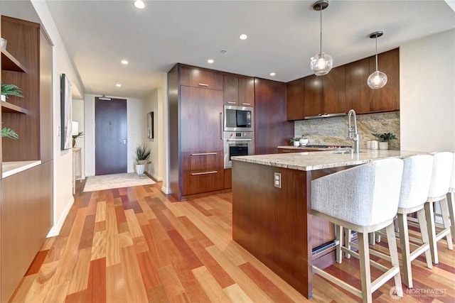 500 106th Ave NE Unit 3109, Bellevue, WA 98004 - kitchen with stainless steel appliances, a peninsula, a kitchen breakfast bar, a sink, and decorative backsplash