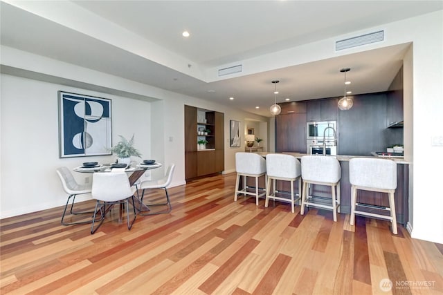 500 106th Ave NE Unit 3109, Bellevue, WA 98004 - kitchen featuring a breakfast bar, light countertops, stainless steel appliances, light wood-style flooring, and visible vents