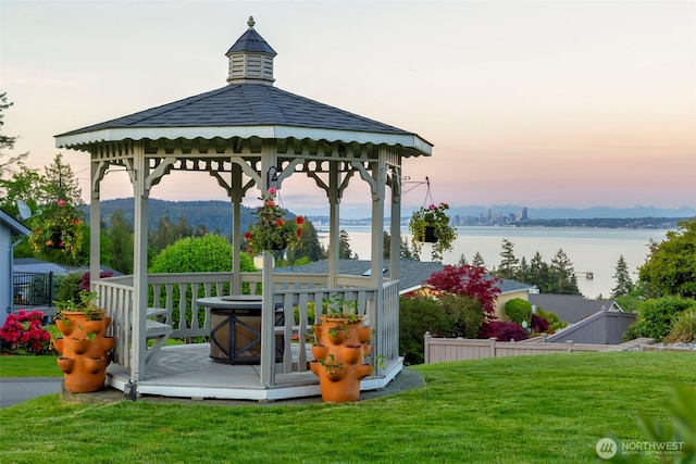 view of property's community with a gazebo, a yard, and a water view