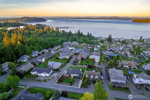 aerial view of property's location with a nearby body of water, nearby suburban area, and property boundaries highlighted
