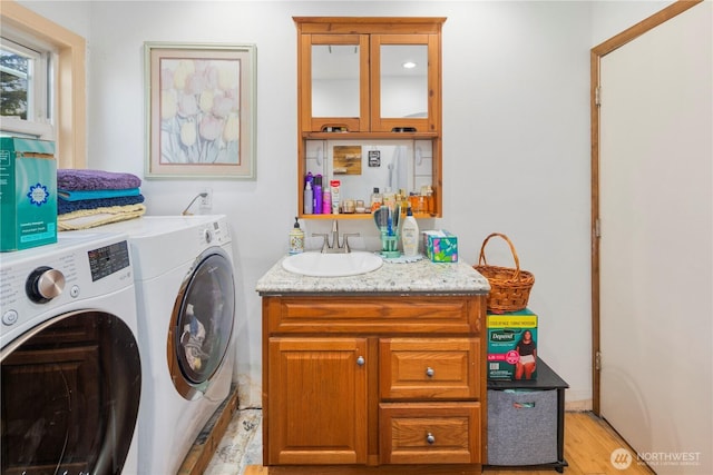 15721 67th Ave NE, Arlington, WA 98223 - washroom featuring separate washer and dryer, indoor bar, cabinet space, light wood finished floors, and a sink