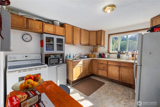 15721 67th Ave NE, Arlington, WA 98223 - kitchen featuring a sink, light countertops, brown cabinetry, and white appliances