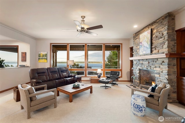 living area featuring carpet, baseboards, a stone fireplace, ceiling fan, and ornamental molding