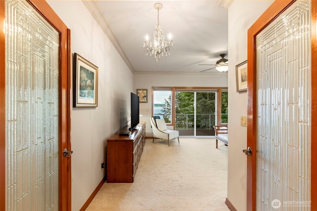hall with light colored carpet, crown molding, baseboards, and a notable chandelier