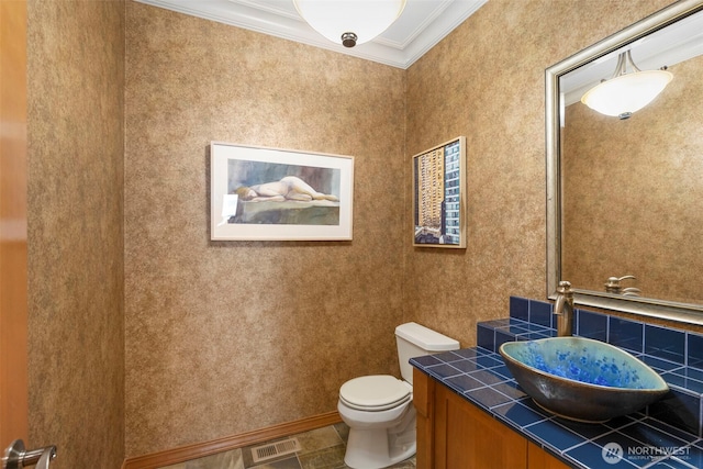 bathroom with vanity, ornamental molding, toilet, and visible vents