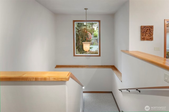 staircase featuring baseboards and carpet floors