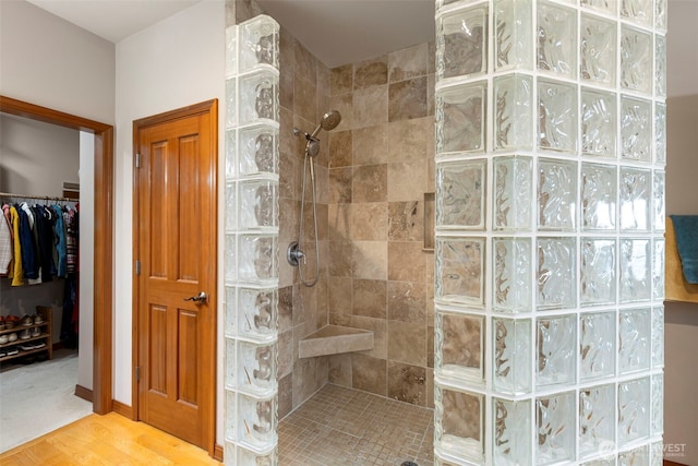 bathroom with walk in shower and a walk in closet