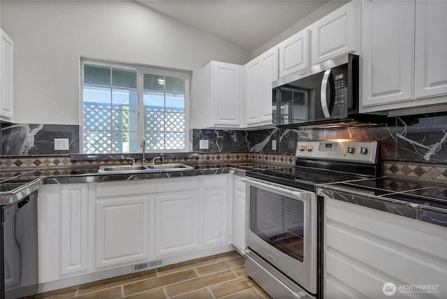 2322 157th Street Ct E, Tacoma, WA 98445 - kitchen featuring stainless steel appliances, dark countertops, visible vents, a sink, and white cabinetry