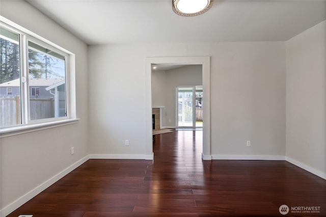 2322 157th Street Ct E, Tacoma, WA 98445 - spare room featuring a fireplace with flush hearth, wood finished floors, and baseboards