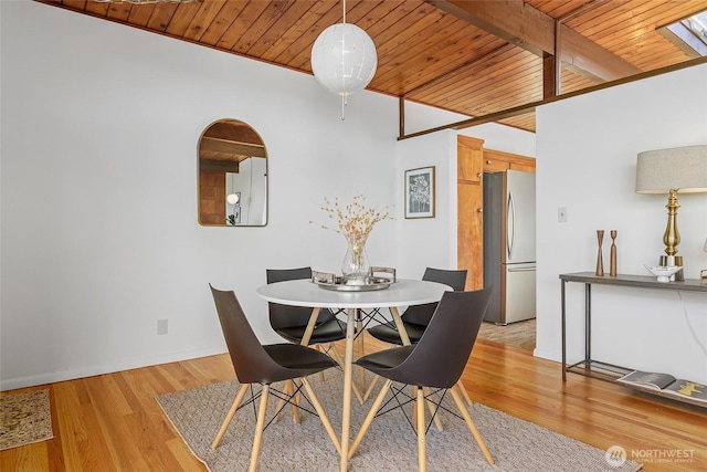 dining space featuring wood ceiling, light wood-style floors, baseboards, and beamed ceiling