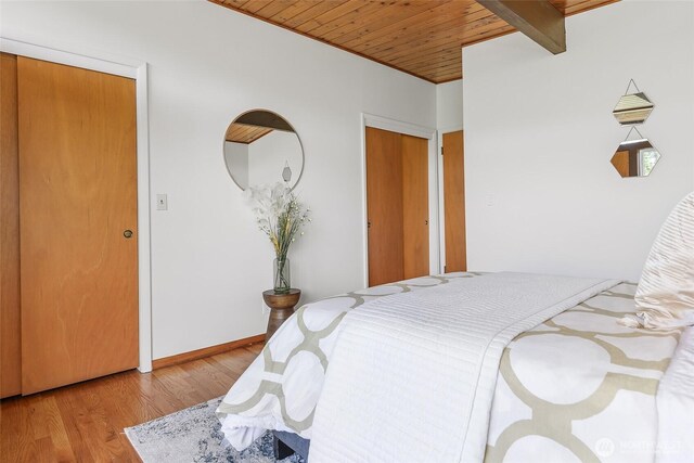 bedroom featuring wood finished floors, wooden ceiling, and baseboards