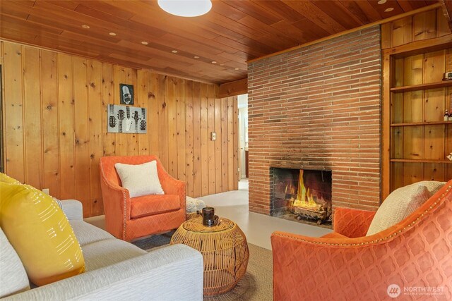 living area featuring wood ceiling, a brick fireplace, and wood walls