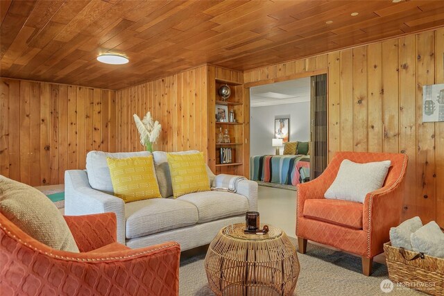 living area with wood walls, wood ceiling, and carpet