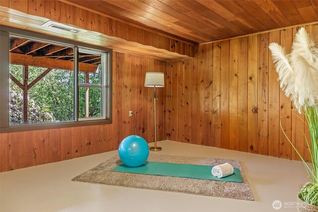 exercise area with wood ceiling and wooden walls