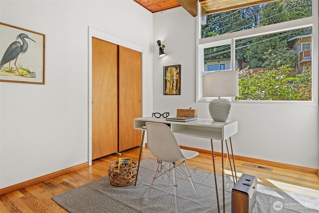 office area featuring wood finished floors, baseboards, wooden ceiling, and beamed ceiling