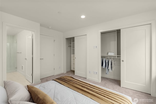 9221C 14th Ave NW, Seattle, WA 98117 - bedroom featuring baseboards, recessed lighting, two closets, and light carpet