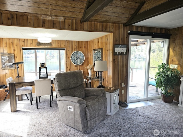 living room with wooden walls, a healthy amount of sunlight, and carpet flooring