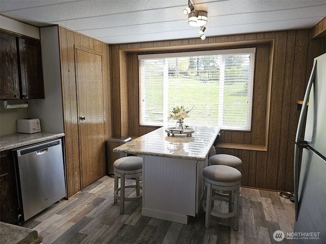 dining area with wood walls and light wood-type flooring