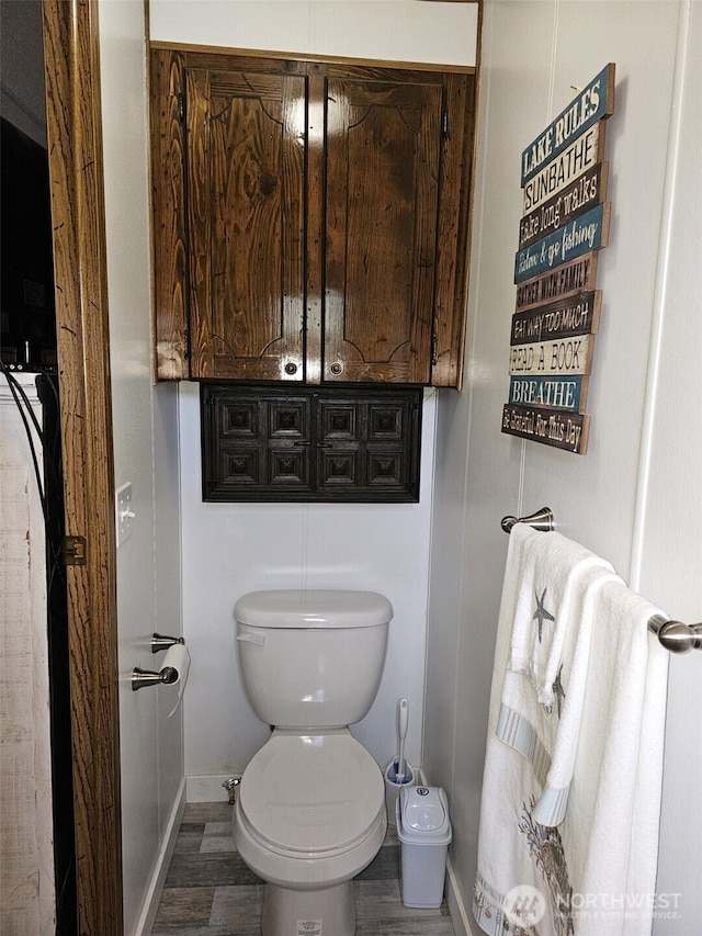 bathroom featuring wood finished floors, toilet, and baseboards