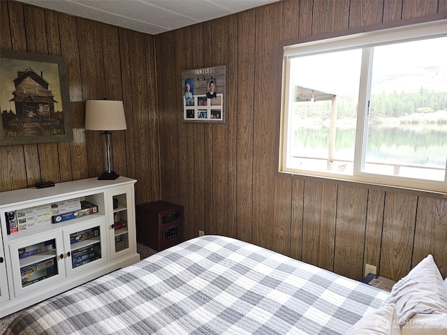 bedroom featuring wooden walls and multiple windows