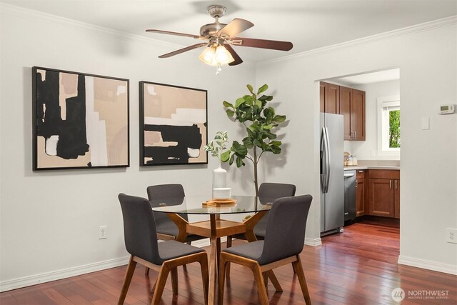 dining area featuring crown molding, baseboards, a ceiling fan, and dark wood-type flooring