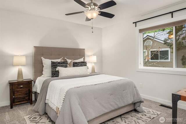 carpeted bedroom featuring baseboards, ceiling fan, and visible vents