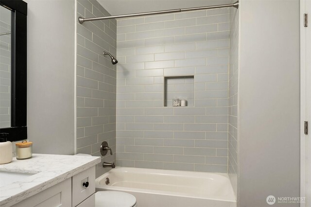 bathroom featuring vanity, washtub / shower combination, and toilet