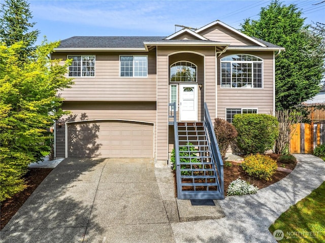 split foyer home featuring a garage, fence, and driveway