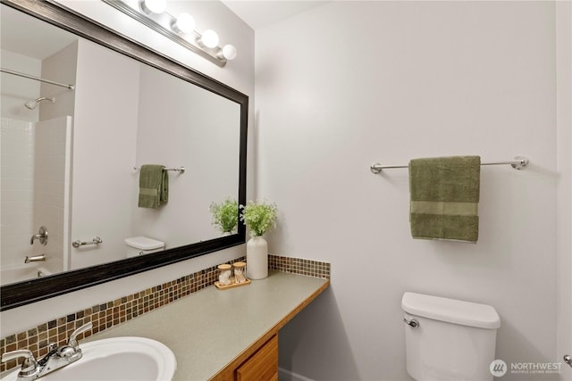 bathroom featuring backsplash, toilet, tub / shower combination, and vanity