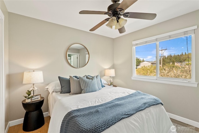 bedroom with baseboards, a ceiling fan, and wood finished floors