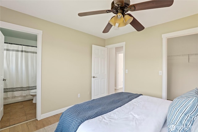 bedroom featuring a closet, baseboards, ensuite bathroom, light wood-type flooring, and a ceiling fan