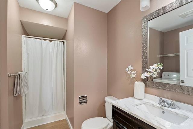 bathroom with vanity, washer / clothes dryer, toilet, and a shower with shower curtain