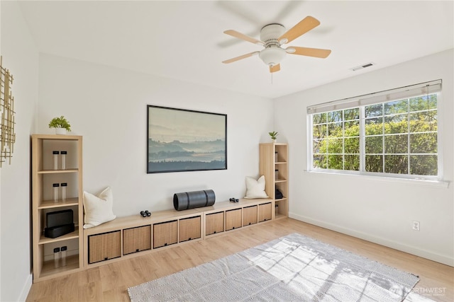 living area featuring baseboards, visible vents, and wood finished floors