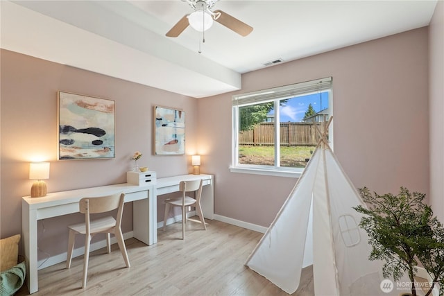 office featuring baseboards, ceiling fan, light wood-type flooring, and visible vents
